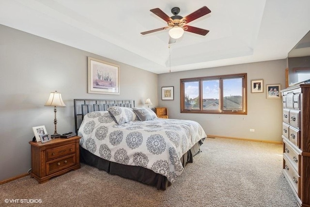 bedroom with ceiling fan, carpet, baseboards, and a raised ceiling