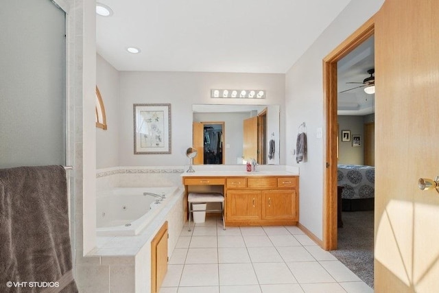 bathroom with ceiling fan, tile patterned flooring, vanity, a whirlpool tub, and ensuite bath