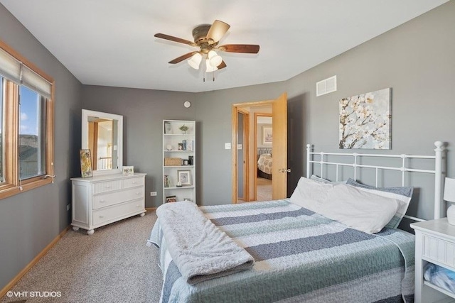 bedroom featuring baseboards, a ceiling fan, visible vents, and light colored carpet