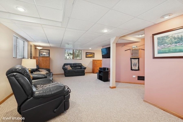 living room featuring carpet flooring, a paneled ceiling, and baseboards