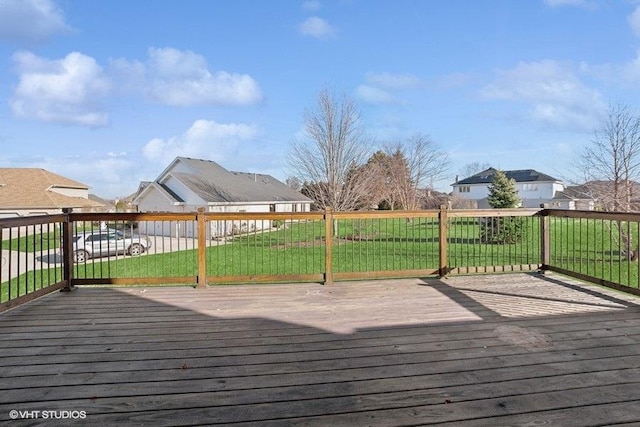 wooden terrace with a residential view and a lawn