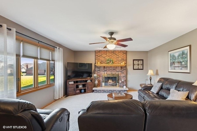 living area with a brick fireplace, ceiling fan, and carpet flooring