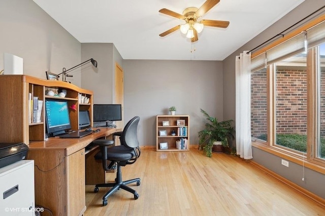 office space featuring baseboards, a ceiling fan, and wood finished floors