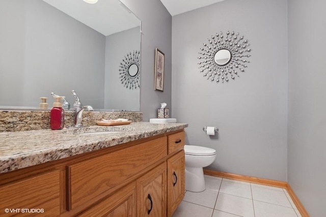 half bath with baseboards, vanity, toilet, and tile patterned floors