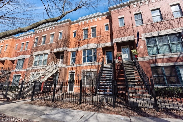 view of property with stairs and a fenced front yard