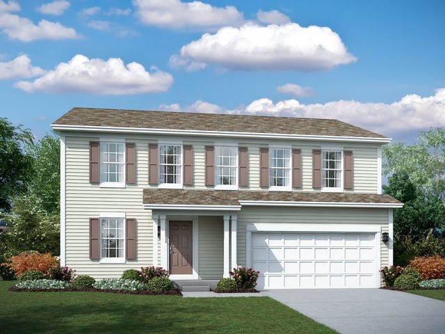 colonial-style house featuring a front yard and a garage