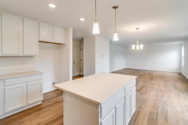 kitchen featuring white cabinetry, hanging light fixtures, light hardwood / wood-style floors, and a kitchen island