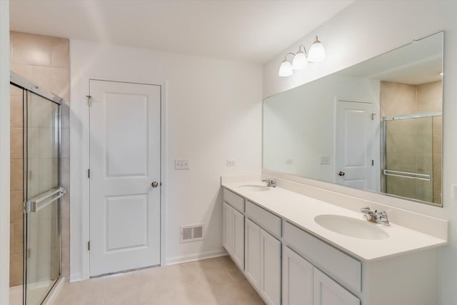 bathroom with vanity, an enclosed shower, and tile patterned floors