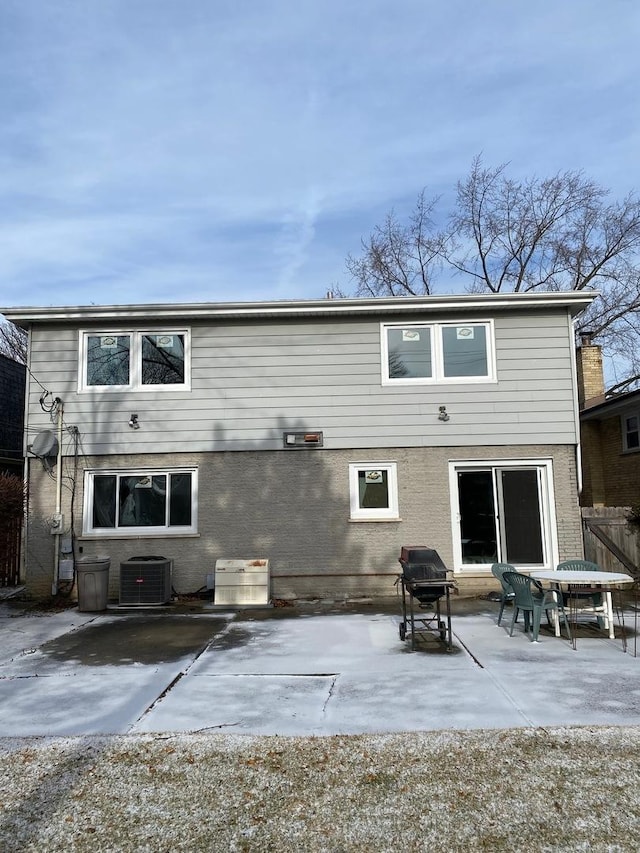 back of property with central air condition unit and a patio