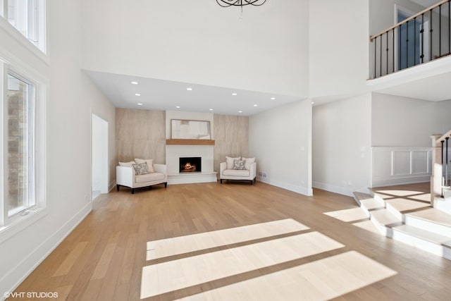 unfurnished room with a towering ceiling and light wood-type flooring