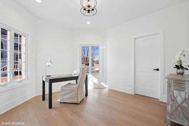 office space with an inviting chandelier and light wood-type flooring