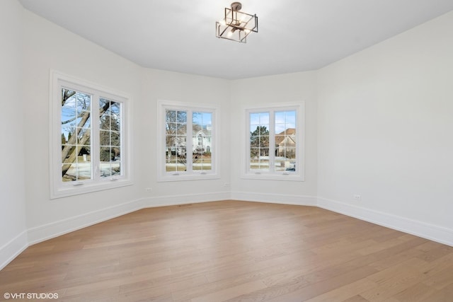 unfurnished dining area featuring a notable chandelier and light wood-type flooring