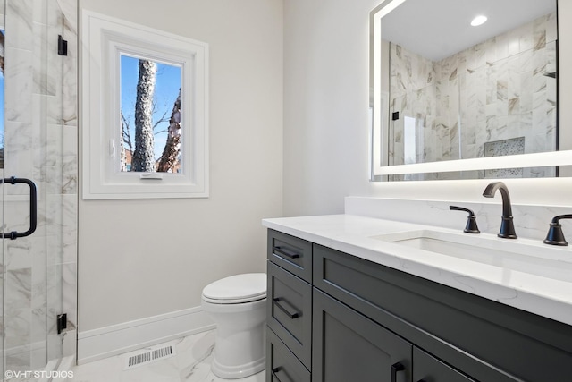 bathroom featuring vanity, toilet, and a shower with shower door