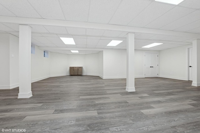 basement featuring a drop ceiling and hardwood / wood-style flooring