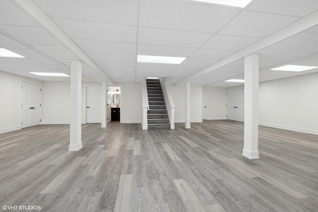 basement with hardwood / wood-style flooring and a paneled ceiling