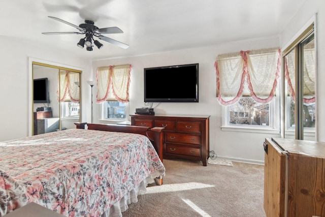 bedroom with a closet, ceiling fan, and light carpet