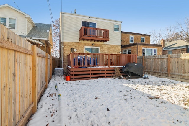 snow covered property featuring a balcony and a deck