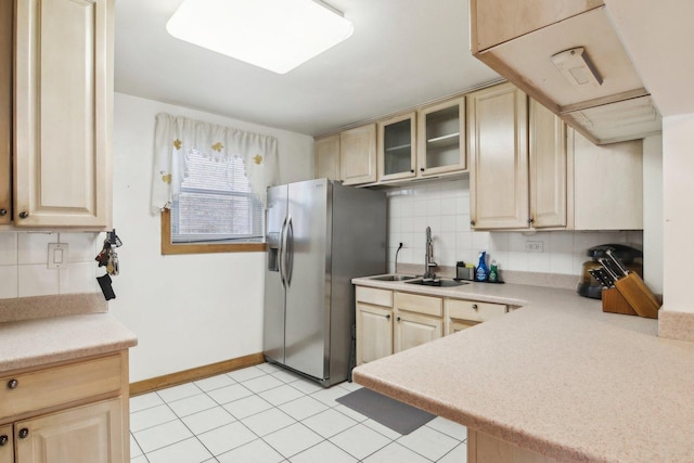 kitchen with sink, light tile patterned floors, decorative backsplash, light brown cabinetry, and stainless steel refrigerator with ice dispenser