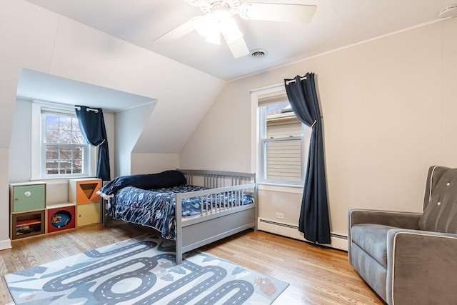 bedroom featuring light hardwood / wood-style flooring, a baseboard radiator, lofted ceiling, and ceiling fan