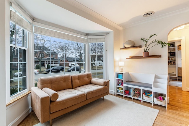 sitting room featuring a wealth of natural light, ornamental molding, and light hardwood / wood-style floors