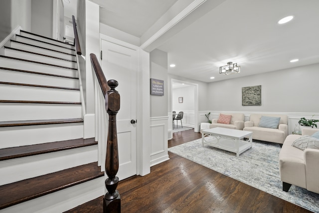 living room with dark wood-type flooring and a notable chandelier