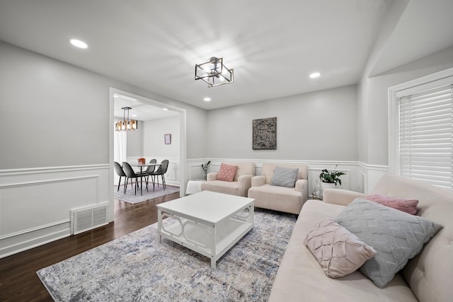 living room with dark wood-type flooring and a chandelier