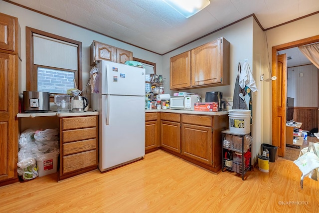 kitchen featuring white appliances, light hardwood / wood-style flooring, and crown molding