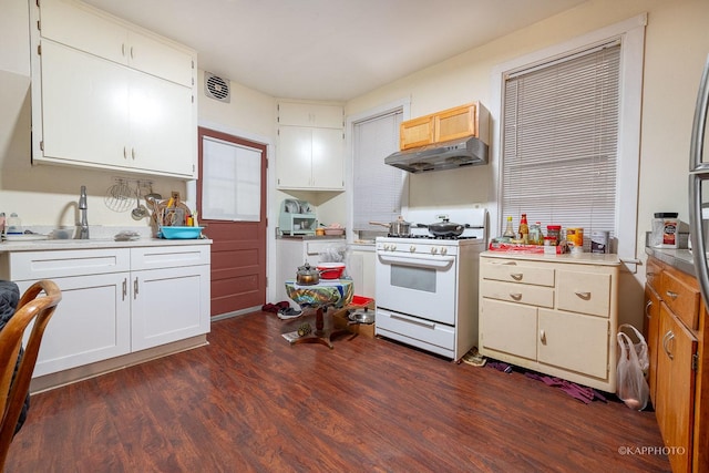 kitchen with white cabinets, dark wood-type flooring, white gas stove, and sink