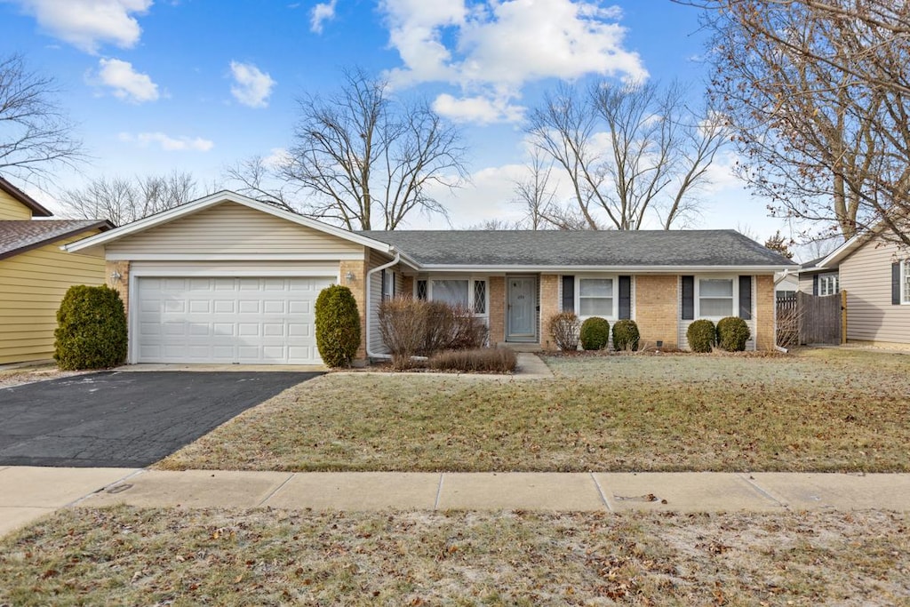 ranch-style house with a front yard and a garage