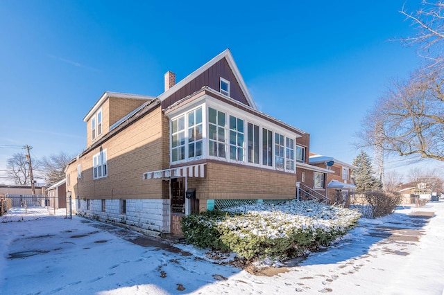 view of snowy exterior with a sunroom