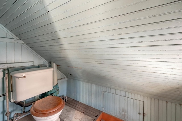 bathroom featuring wood walls, wood ceiling, lofted ceiling, and toilet