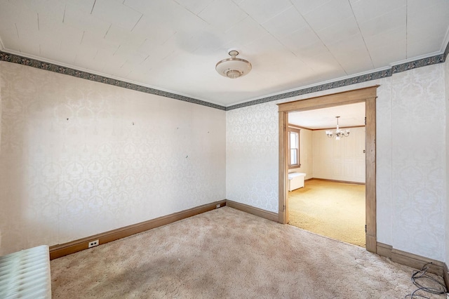 carpeted empty room with crown molding and an inviting chandelier