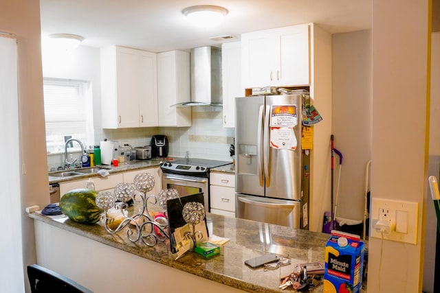 kitchen with sink, white cabinets, stainless steel appliances, and wall chimney range hood