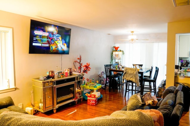 living room featuring ceiling fan and dark hardwood / wood-style flooring