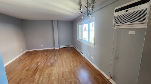 interior space featuring a baseboard heating unit, light hardwood / wood-style flooring, a wall unit AC, and an inviting chandelier