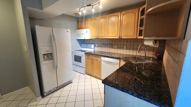 kitchen with sink, dark stone countertops, white appliances, decorative backsplash, and light tile patterned floors