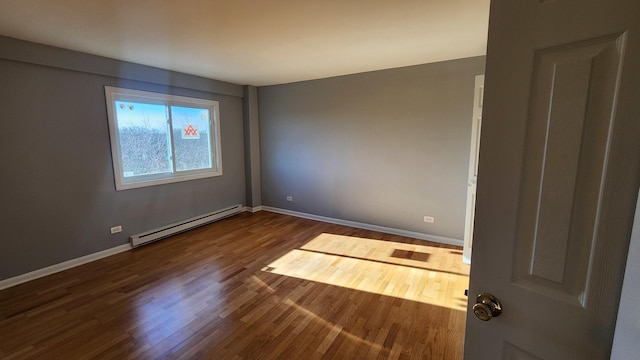 unfurnished room with hardwood / wood-style floors and baseboard heating