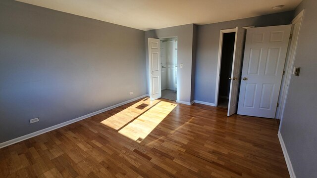 unfurnished bedroom with dark wood-type flooring