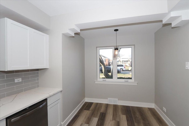 kitchen with pendant lighting, backsplash, white cabinets, stainless steel dishwasher, and light stone countertops