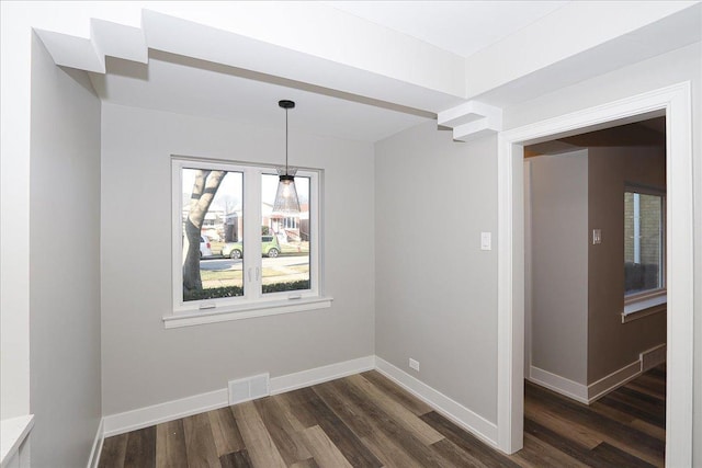 unfurnished dining area with dark wood-type flooring