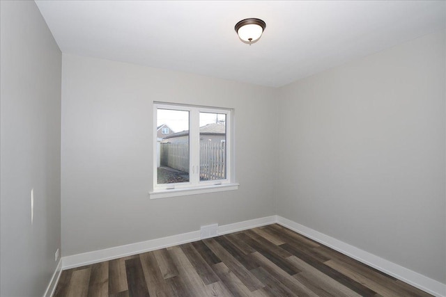 unfurnished room with dark wood-type flooring