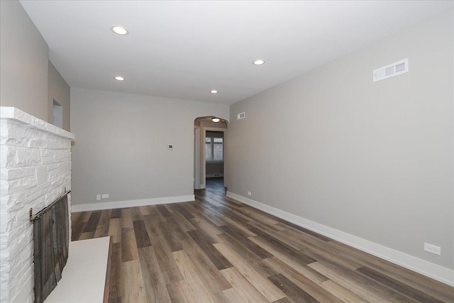 unfurnished living room featuring a fireplace and dark hardwood / wood-style flooring