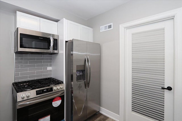 kitchen with backsplash, white cabinetry, stainless steel appliances, and dark hardwood / wood-style floors