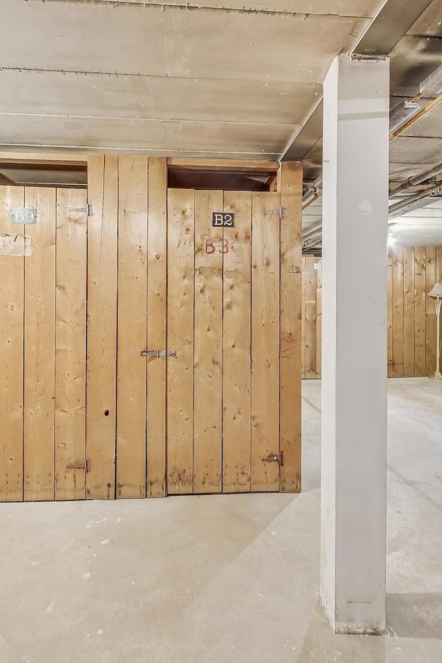 basement featuring wood walls