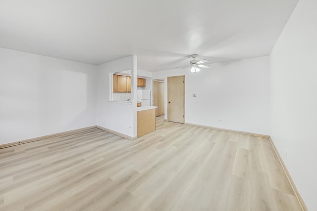 empty room with ceiling fan and light wood-type flooring