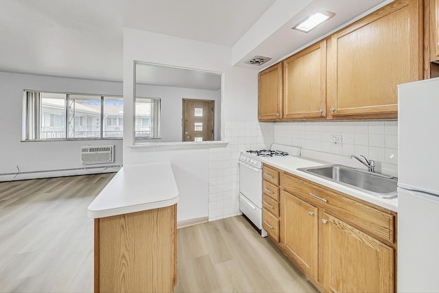 kitchen with sink, a baseboard radiator, tasteful backsplash, light hardwood / wood-style floors, and white appliances