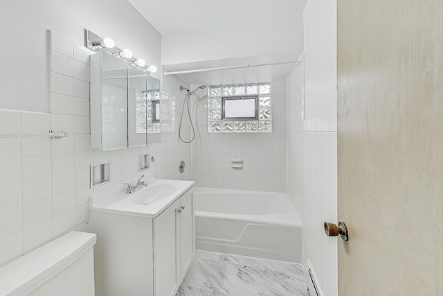 full bathroom with vanity, a baseboard heating unit, tile walls, toilet, and tiled shower / bath