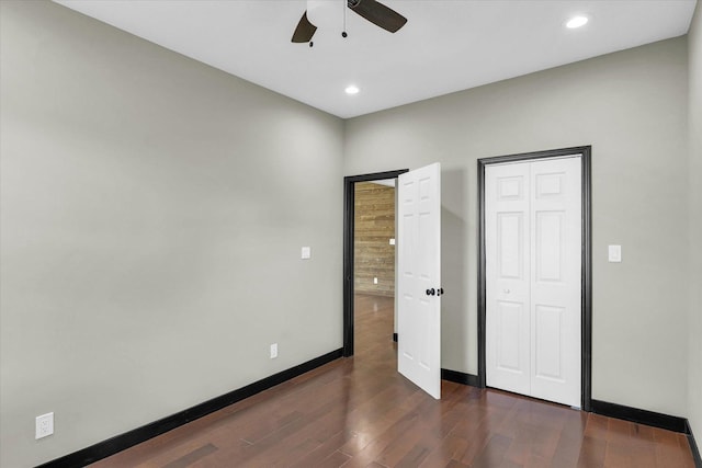 unfurnished bedroom with ceiling fan and dark wood-type flooring