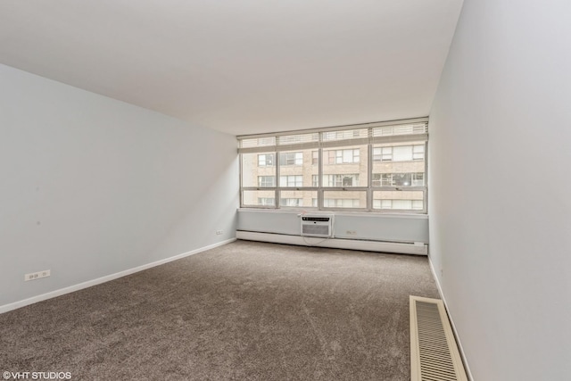 carpeted empty room featuring a baseboard heating unit