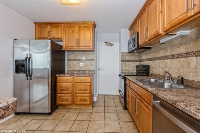 kitchen with tasteful backsplash, sink, light tile patterned floors, and appliances with stainless steel finishes